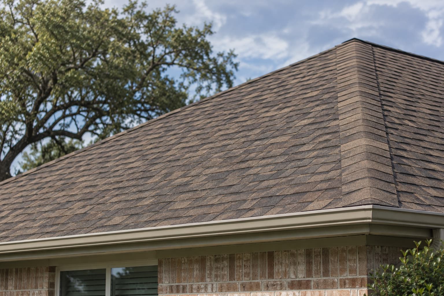 AI-generated illustration of brown architectural asphalt shingles on a brick Texas home